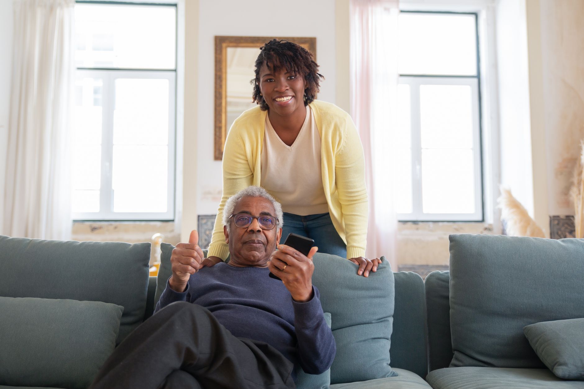 A smiling senior client and caregiver at home